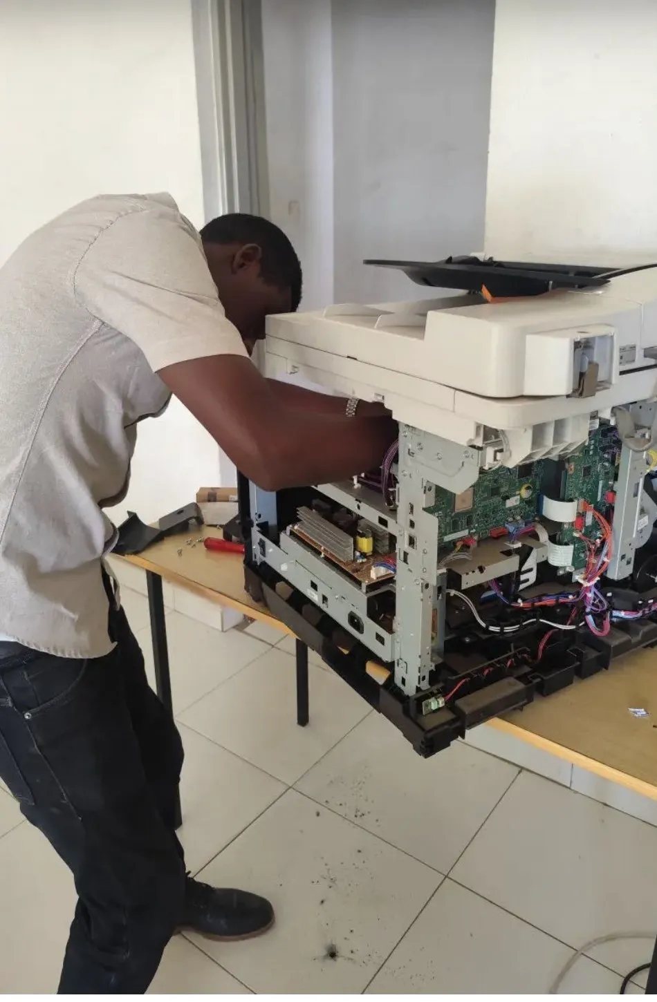 Technicien STS réparant la carte électronique d’un photocopieur